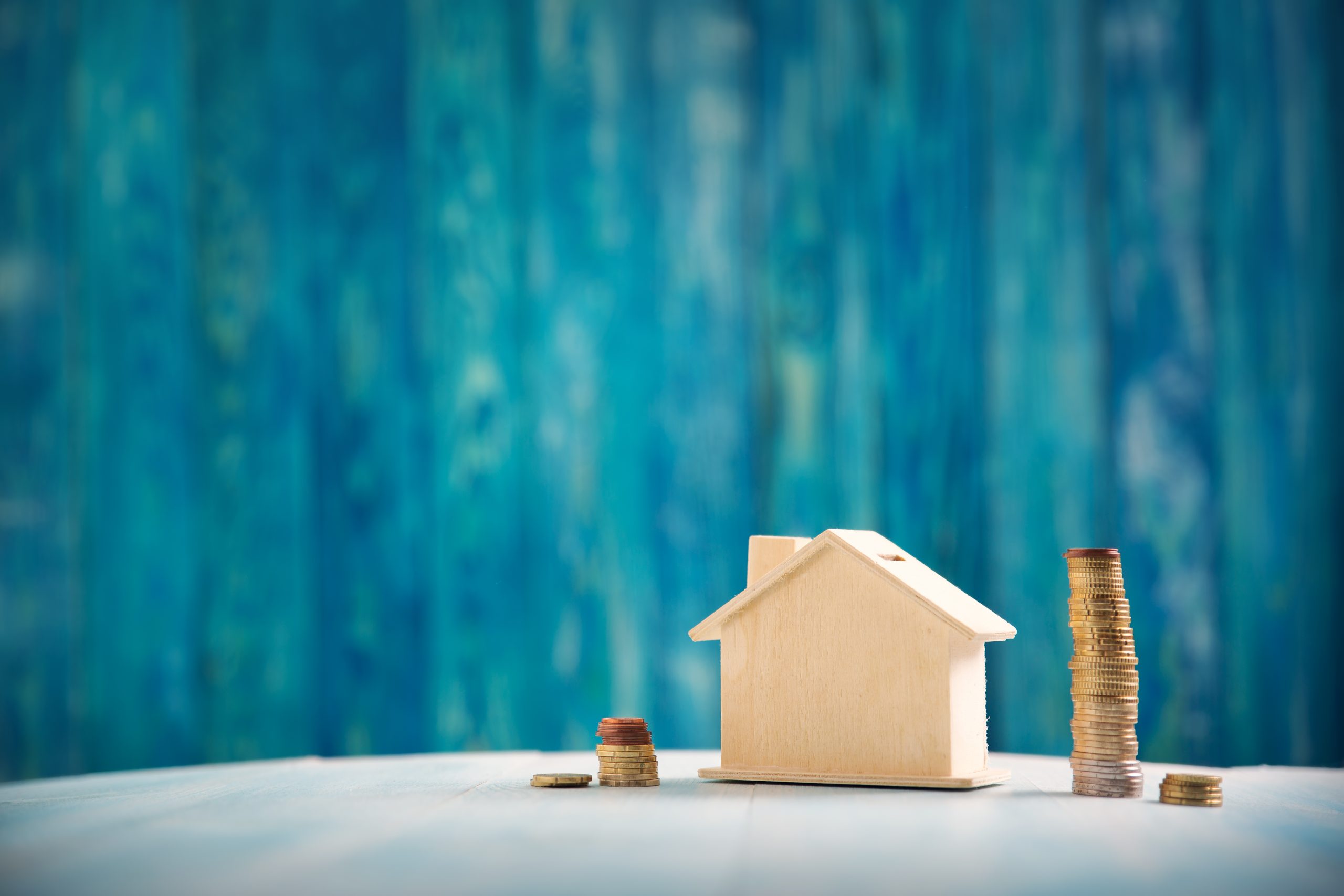 Red house on wooden background with banknotes